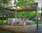 Milano gazebo with a flat roof covers a patio deck with garden furniture so that mother and daughter can enjoy the outdoors