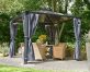 Gray aluminium gazebo with polycarbonate roof panels and privacy curtains on a patio with dining furniture