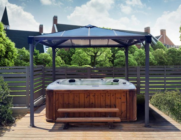 On a deck patio is a 10' x 10' aluminum hot tub gazebo with polycarbonate roof panels to cover the hot tub
