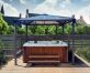 On a deck patio is a 10' x 10' aluminum hot tub gazebo with polycarbonate roof panels to cover the hot tub