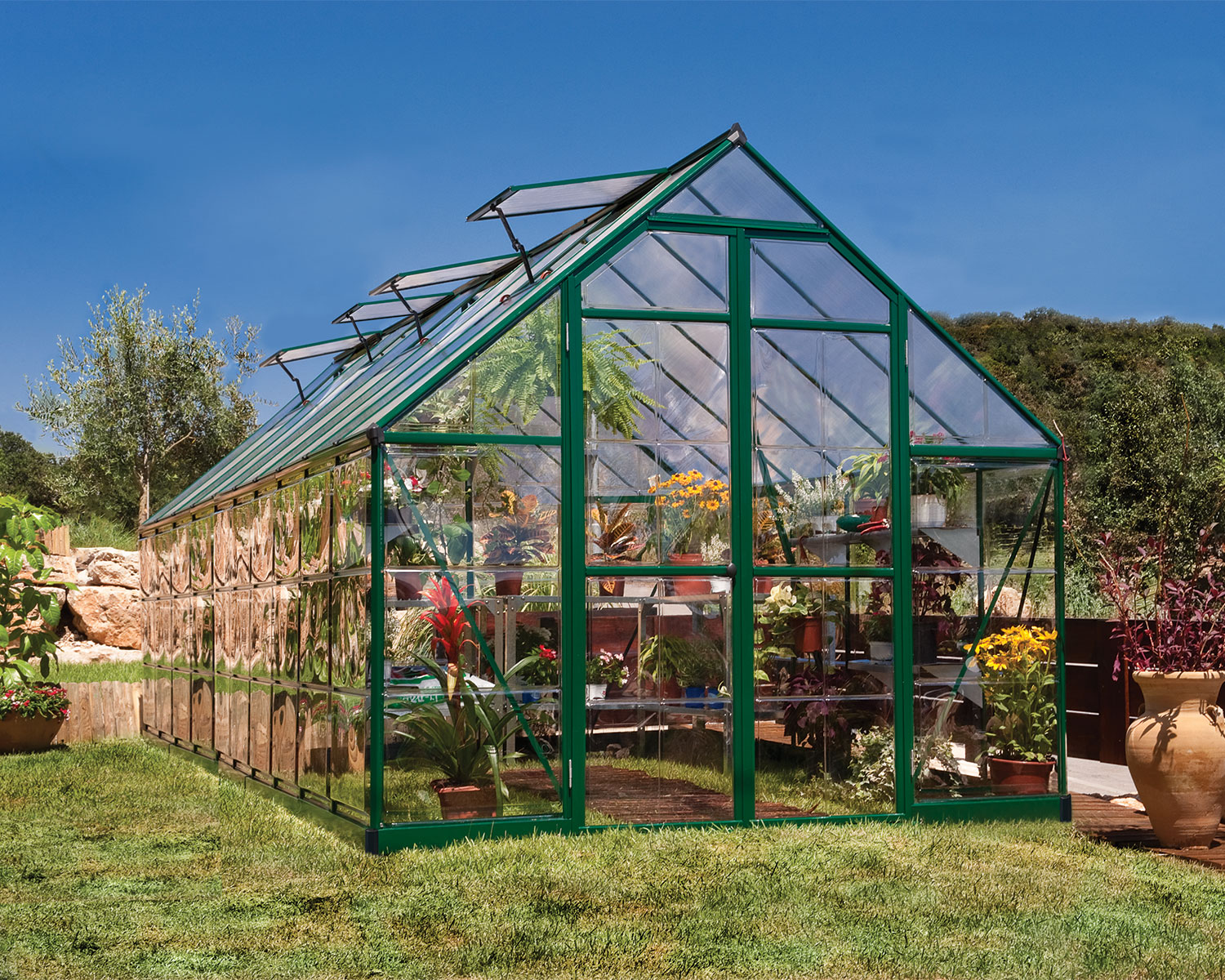 Greenhouse Balance 8 ft. x 20 ft. Green Structure & Hybrid Panels open door on a lawn full of plants