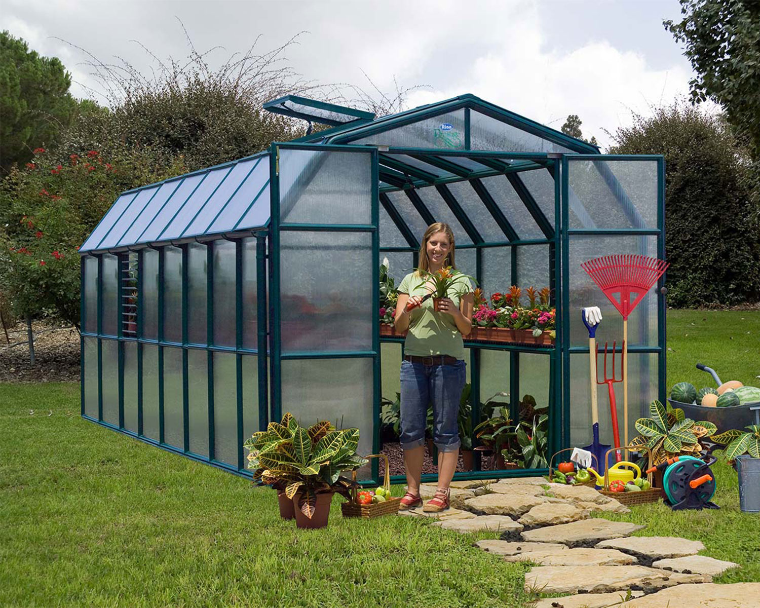 Greenhouse Prestige 8 ft. x 16 ft. Green Structure & Clear Wall Panels on a lawn open door full of plants